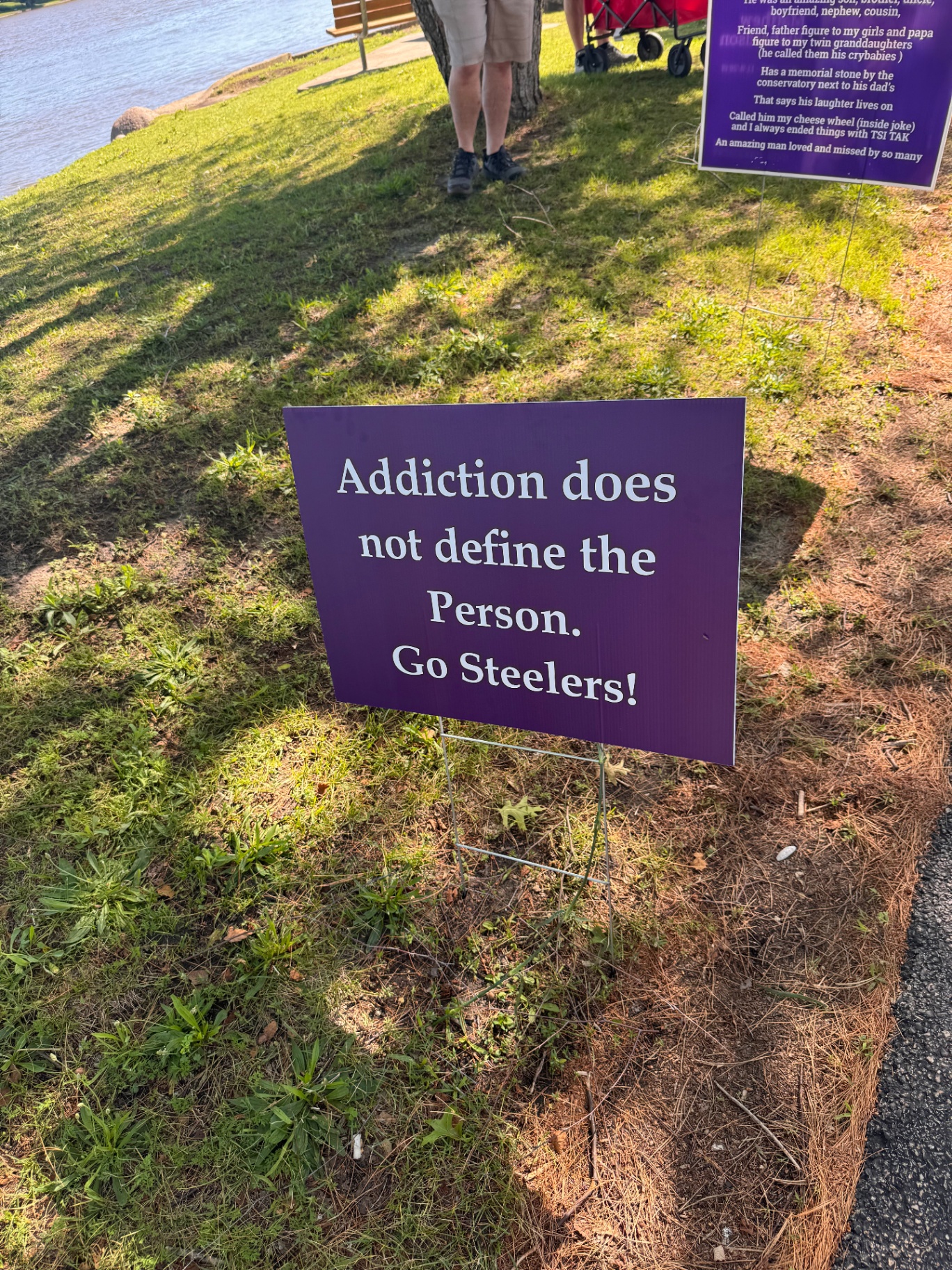 A purple sign reading Addiction does not define the person. Go Steelers!