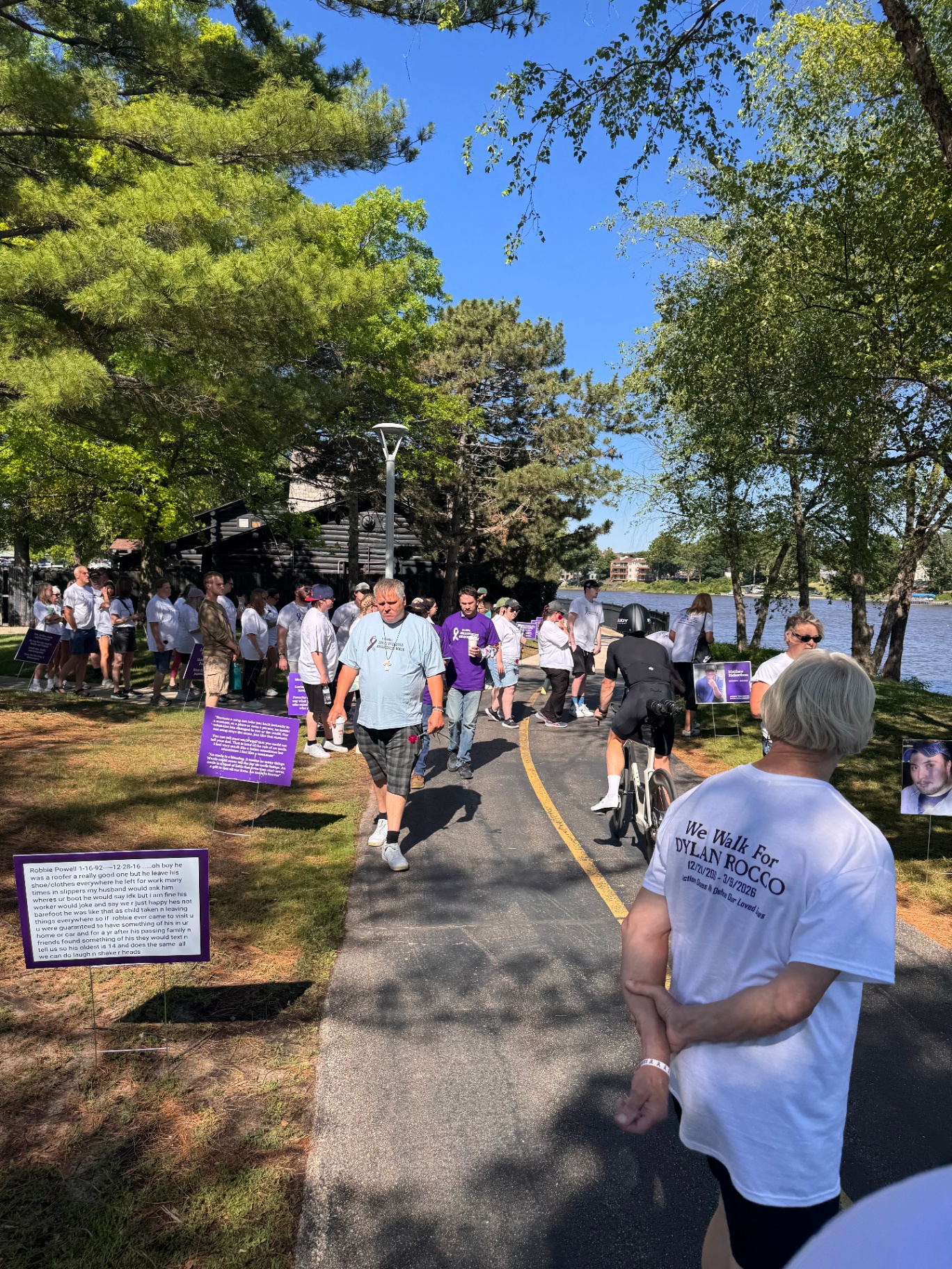 Walkers along the lakeside path passing tribute signs
